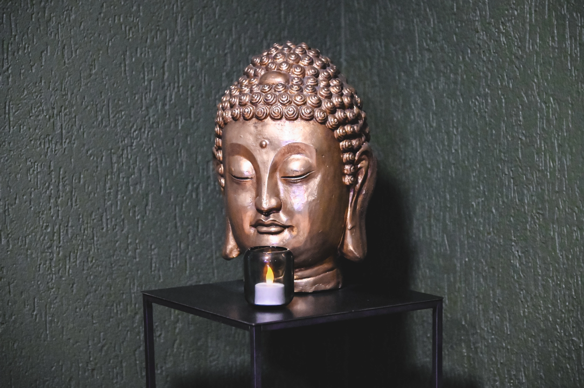 Buddha Statue mit Kerze. Zellspa bietet ein schönes Ambiente für die Kundinnen und Kunden.