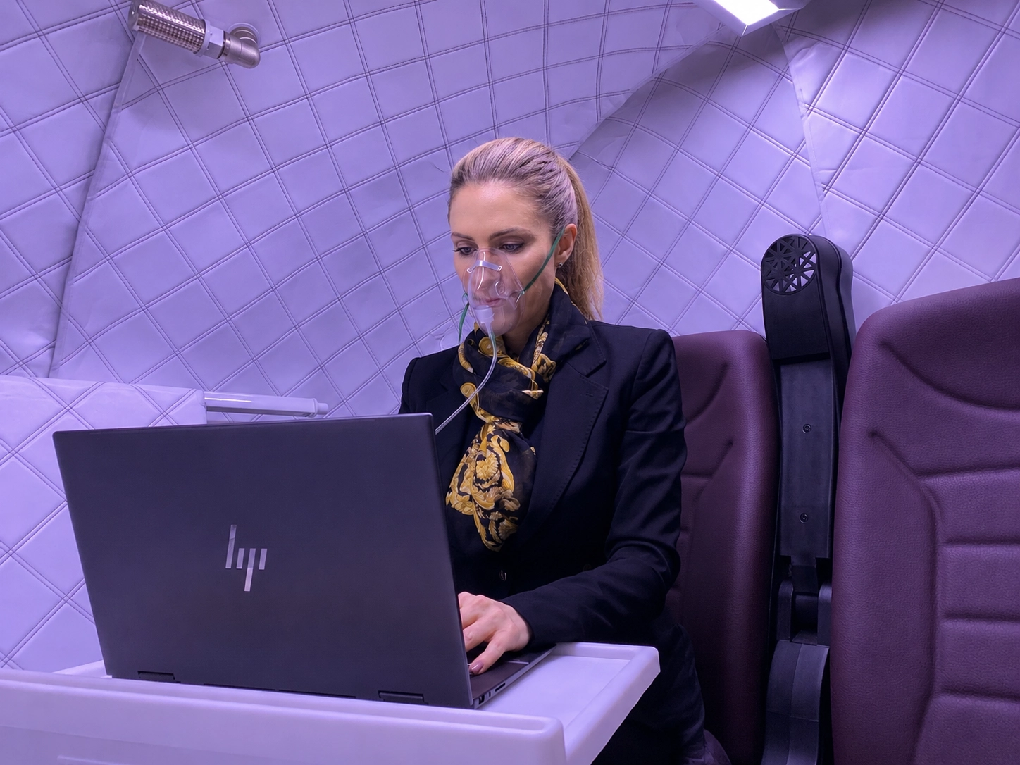 Kundin arbeitet am Laptop während der HBOT Behandlung